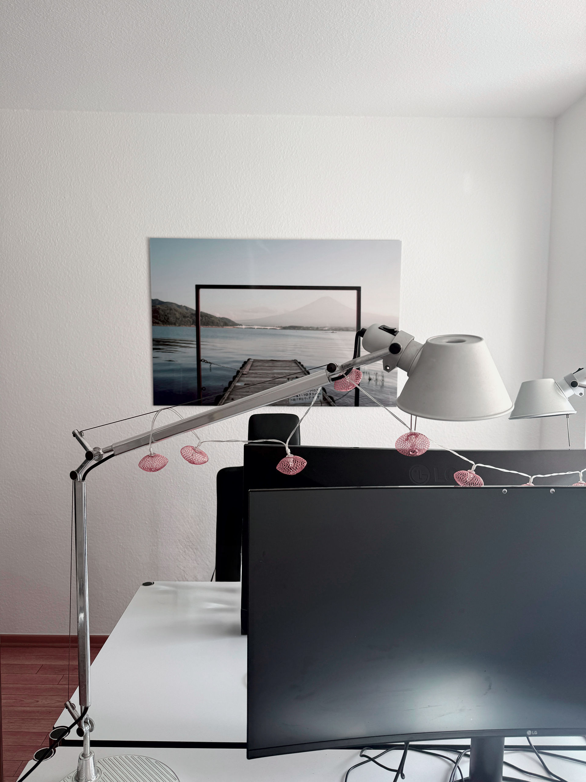 Arbeitsplatz mit Leuchte und Bildschirmen im Divine-Büro